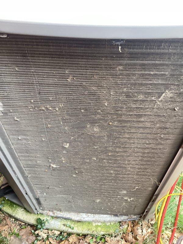# HVAC Maintenance - ACM Completed

Performed scheduled preventive maintenance on residential air conditioning condenser unit. Upon arrival, conducted visual inspection which revealed heavily soiled condenser coils with significant accumulation of dirt, debris, and organic matter throughout the fin surfaces. Multiple fins displayed bent and damaged sections, particularly in upper areas of the heat exchanger.

Documented pre-service condition with photographs showing extensive contamination on both exterior and interior coil surfaces, including cobwebs, dust buildup, and environmental debris lodged between fin spaces. Ground-level vegetation and algae growth were noted around unit base, indicating prolonged exposure without recent servicing.

Proceeded with comprehensive coil cleaning using appropriate cleaning solutions and equipment to remove accumulated dirt and restore heat transfer efficiency. Addressed clogged fin spaces to improve airflow through the heat exchanger. Straightened 
