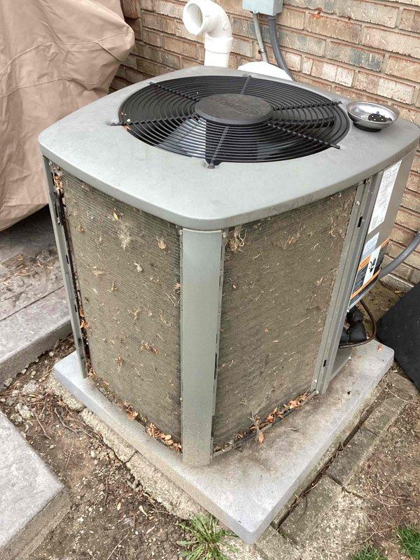 Completed annual air conditioning maintenance on residential outdoor condenser unit. Performed comprehensive system inspection including cleaning of heat exchanger coils which showed significant dirt and debris accumulation, verified proper fan motor operation, checked refrigerant levels, inspected electrical connections and components, and cleared debris from around unit base and concrete pad. Removed accumulated leaves and organic matter from condenser cabinet exterior and surrounding area. Tested system startup and shutdown cycles to ensure proper operation. Unit operational and running efficiently following maintenance service.