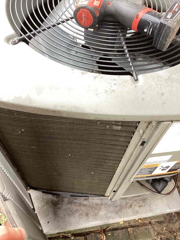 Completed annual air conditioning maintenance on residential outdoor condenser unit. Performed comprehensive system inspection including cleaning of heat exchanger coils which showed significant dirt and debris accumulation, verified proper fan motor operation, checked refrigerant levels, inspected electrical connections and components, and cleared debris from around unit base and concrete pad. Removed accumulated leaves and organic matter from condenser cabinet exterior and surrounding area. Tested system startup and shutdown cycles to ensure proper operation. Unit operational and running efficiently following maintenance service.