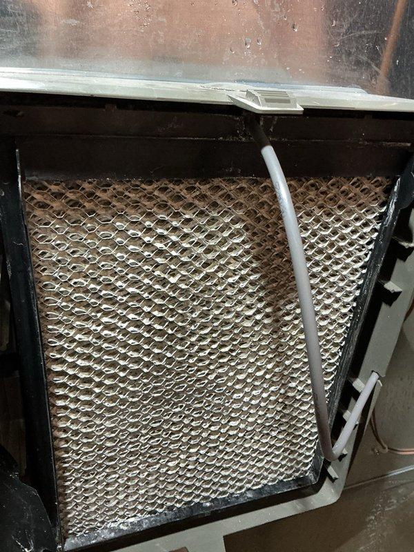 Completed annual cooling maintenance on residential air conditioning system. Inspected evaporator coil and noted dust accumulation on upper mesh surface requiring attention during routine maintenance. Documented system condition and exterior unit foundation area, observing normal wear patterns and mineral deposits on concrete base consistent with standard outdoor HVAC installation exposure to environmental elements.