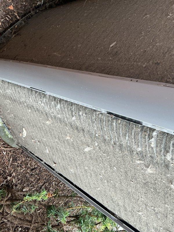 Completed annual cooling maintenance on residential air conditioning system. Inspected evaporator coil and noted dust accumulation on upper mesh surface requiring attention during routine maintenance. Documented system condition and exterior unit foundation area, observing normal wear patterns and mineral deposits on concrete base consistent with standard outdoor HVAC installation exposure to environmental elements.