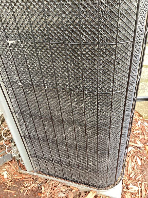 Completed annual preventive maintenance on residential air conditioning system. Unit inspected and found in operational condition with protective grille intact and secure. Observed debris accumulation around base of condenser unit; no filter replacement required per service specifications.