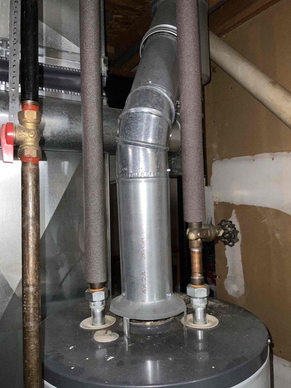 Provided estimate for replacement of non-functioning natural draft standard water heater in condo utility room. Assessed existing unit installed in 2014 with visible wear and confirmed natural draft venting configuration. Documented current plumbing connections including copper supply lines with shutoff valves, pressure relief valve, and existing drain pan setup for replacement specifications.