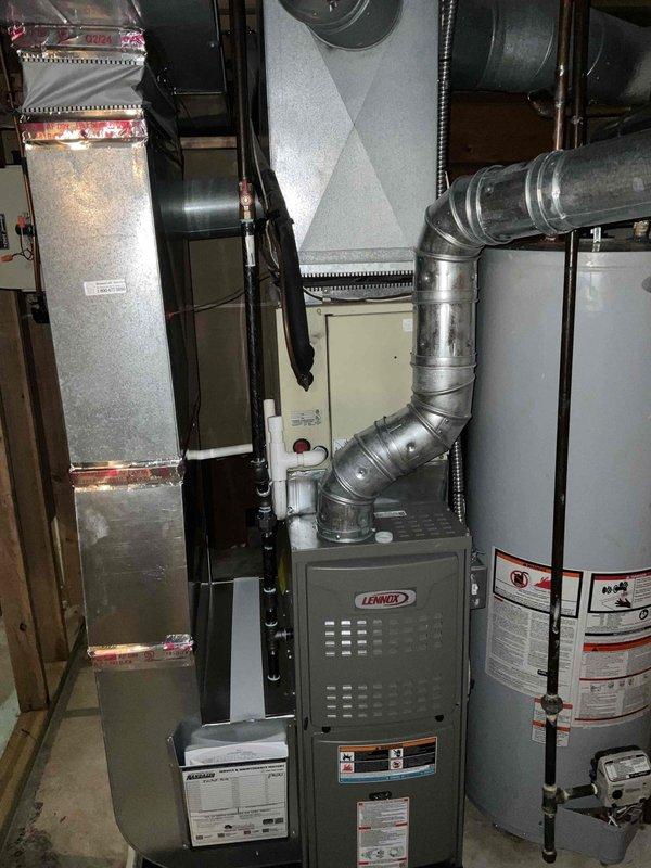 Provided estimate for complete air conditioning system replacement. Existing outdoor condenser unit from 1993 showed extensive rust staining, weathering, and age-related deterioration, resulting in non-operational cooling system. Assessed outdoor unit positioned on concrete pad, noted compromised cabinet integrity and failing components. Evaluated indoor furnace system in basement mechanical room, including existing Lennox furnace and ductwork configuration. Prepared comprehensive replacement proposal for new cooling equipment to restore residential comfort system functionality.