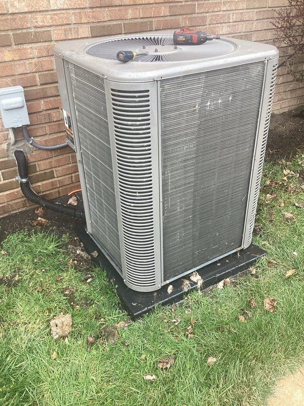Completed annual cooling maintenance on residential air conditioning system. Contacted customer prior to arrival as requested. Performed comprehensive inspection of outdoor condenser unit, including examination of cabinet condition, coil fins, and fan assembly. Documented equipment condition through photographic records showing unit positioned on concrete pad against exterior brick wall with electrical disconnect and conduit properly installed. Condenser exhibited normal weathering and outdoor exposure with accumulated surface dirt and debris on metal panels and louvered vents. Verified unit accessibility and clearance around equipment for proper airflow and future service access.