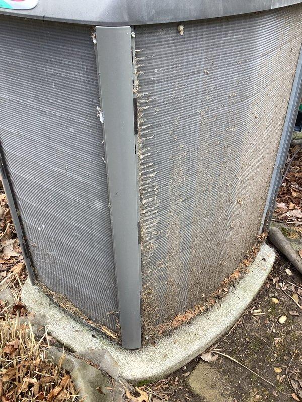 Completed annual cooling maintenance on outdoor condensing unit. Inspected heat exchanger coils, corner guards, and unit foundation for proper operation and structural integrity. Changed furnace filters and documented unit condition with exterior showing normal weathering and debris accumulation on concrete pad requiring no immediate corrective action.