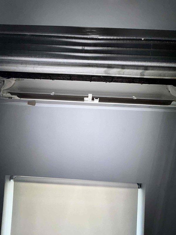 Responded to service call for Mitsubishi mini split system experiencing water leakage in bathroom installation. Upon arrival, inspected 23-year-old unit and confirmed active water leak from indoor air handler. Previous contractor had identified potential kinked drain line as source of issue. Performed thorough visual inspection of condensate drainage system, including primary drain line routing from air handler through exterior wall penetration. Examined refrigerant line set and condensate piping installation along exterior siding, noting multiple bends in metallic conduit system. Accessed ceiling-mounted air handler unit to assess internal drain pan condition and verify proper drainage flow. Corrected kinked section of condensate drain line that was restricting water flow and causing backup into the unit. Tested system operation and verified proper condensate drainage with no further leakage detected.