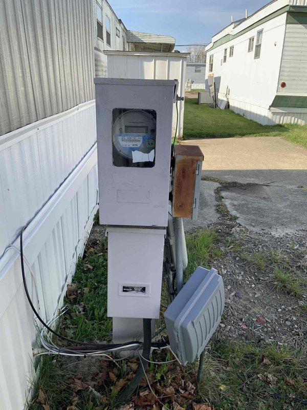 Conducted HVAC replacement estimate for mobile home with 16-year-old International Comfort rooftop AC unit experiencing thermostat communication failure. Diagnosed no voltage at thermostat while confirming proper voltage at unit, indicating damaged or disconnected stat wire requiring complete replacement run. Assessed severely corroded outdoor electrical panel and weathered utility connections serving the HVAC system. Provided estimate options for complete thermostat wire installation with additional labor requirements and discussed system replacement considerations given equipment age and existing gas furnace configuration.