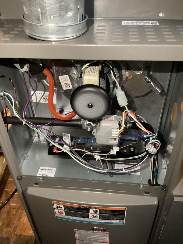 Completed annual heating maintenance on residential furnace system as part of preventative maintenance membership. Performed comprehensive tune-up inspection including visual examination of all internal components, electrical connections, and safety systems. Removed access panels to inspect inducer motor assembly, heat exchanger, control board, and wiring harnesses. Verified all wire connections secure with proper color coding intact (orange, purple, white, black, and blue conductors). Inspected draft inducer motor housing and mounting for proper operation. Examined control board module and associated electrical connections for signs of wear or damage. Confirmed all manufacturer identification labels and warning decals present and legible. Checked ductwork connections and flexible connector at plenum interface. System found to be in proper working condition with no deficiencies noted. All components operating within normal parameters. Unit ready for heating season operation.