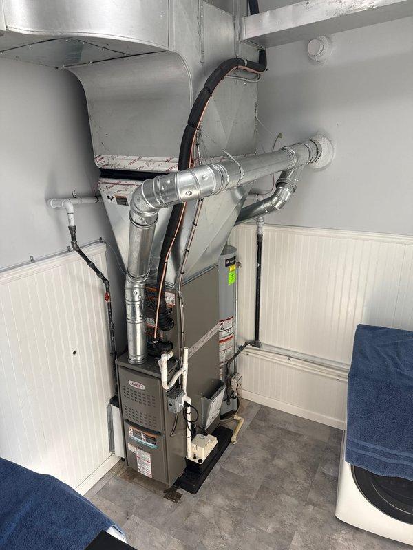 Completed full HVAC system installation including a 70,000 BTU furnace and 2-ton air conditioning unit with rear discharge configuration. Installed new electrical circuit with conduit routing to support system requirements. Connected all supply and return ductwork, gas lines, condensate drainage, and refrigerant lines. Mounted furnace on platform base and secured all mechanical, electrical, and ventilation components per code requirements.