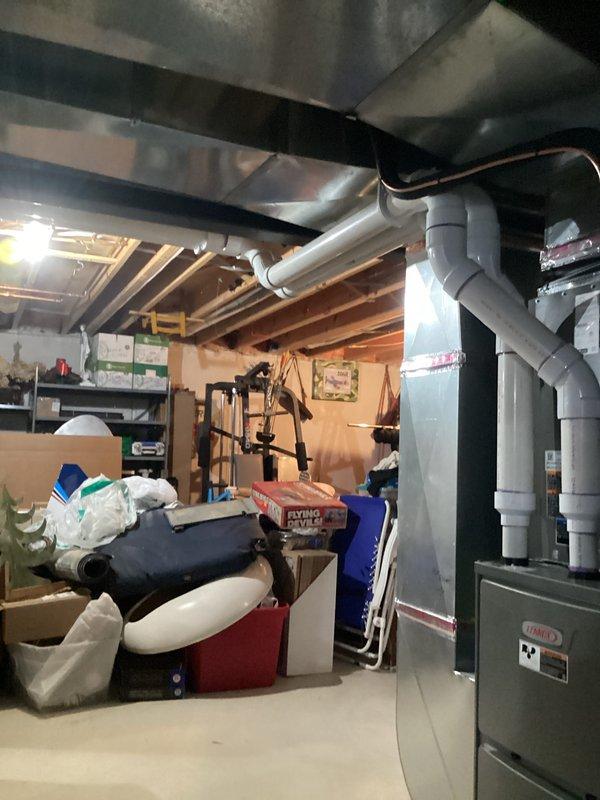 Completed full HVAC system installation including 110,000 BTU gas furnace and 4-ton air conditioning unit with rear discharge configuration in basement utility area. Installed white PVC venting system with proper termination and elbowing, reconnected electrical service at main panel with appropriate circuit breaker installation, and verified all mechanical and electrical connections per code requirements. All permits obtained and system tested for proper operation upon completion.