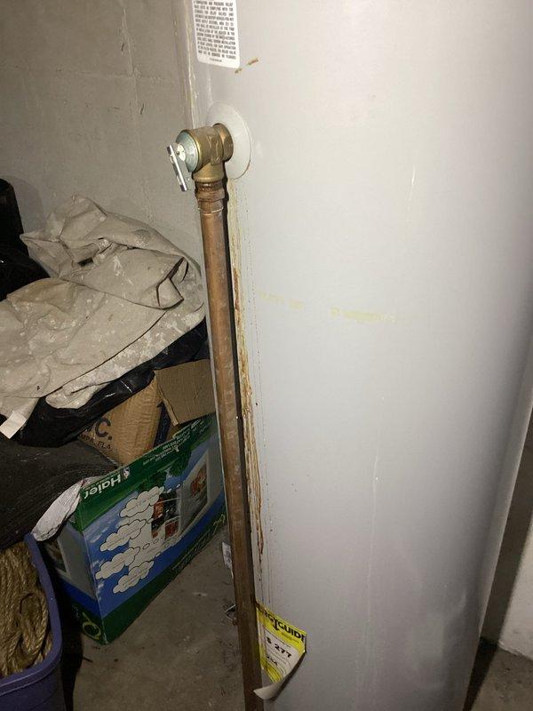 Responded to service call for leaking tanked water heater. Upon arrival, found residential gas-fired water heater with extensive rust staining and corrosion on tank exterior, indicating active leak from tank body. Inspected all plumbing connections, pressure relief valve, and supply lines to confirm leak source was compromised tank integrity rather than fitting failure. Documented unit condition with photographs showing deteriorated tank with rust streaks, corroded surfaces, and temporary bucket placed on top to catch condensation. Assessed copper supply piping and shutoff valve configuration. Advised customer that tank failure requires complete water heater replacement as tank leaks cannot be repaired. Provided recommendations for new unit installation.