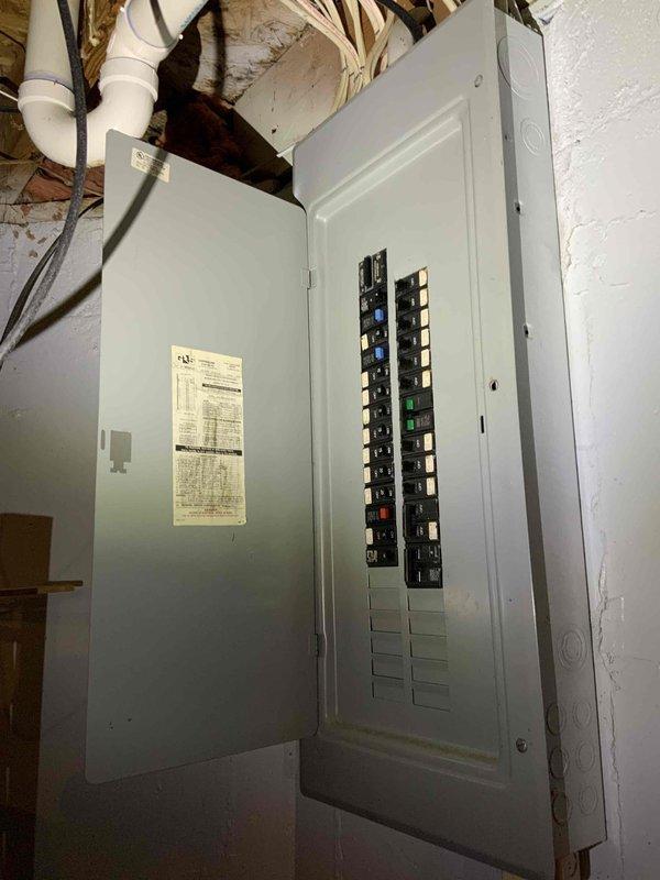 Completed site assessment for replacement estimate of 14-year-old furnace and air conditioning system in residential basement installation. Evaluated existing natural gas furnace and outdoor condensing unit positioned on exterior gravel pad adjacent to white brick foundation. Documented current system configuration including electrical service panel setup, conduit routing, and equipment accessibility for future BOGO replacement installation.