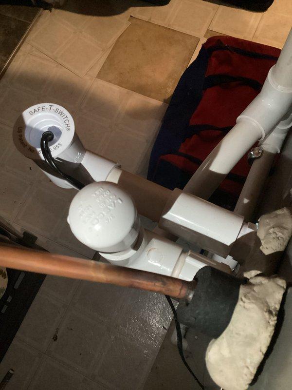 Completed violation repair callback on 3-ton AC system in basement of 1950s-built residence. Installed SAFE-T-SWITCH secondary float switch in auxiliary condensate drain line per code requirements, connecting to existing PVC drain piping and copper line configuration. Verified proper operation of safety switch and confirmed wiring connections to control board terminal block, ensuring system shutdown protection in the event of drain line blockage.