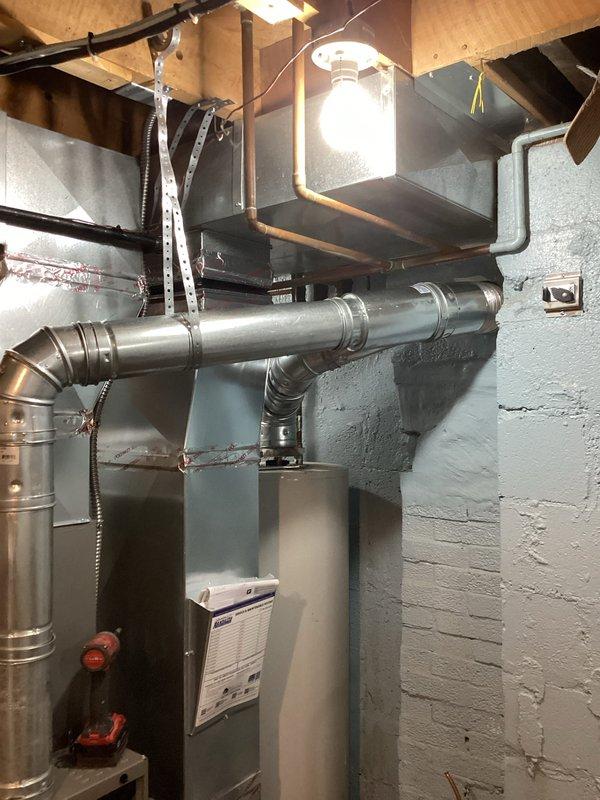 Completed full HVAC system installation including 70,000 BTU furnace and 2-ton air conditioning unit in basement utility area. Installed new furnace on platform with complete ductwork system featuring galvanized metal supply and return ducts routed through ceiling joists. Connected AC condenser with refrigerant lines and electrical service. Installed flexible and rigid ductwork with proper transitions and elbows to distribute conditioned air throughout residence. Secured all ductwork to structural framing with metal strapping and hangers. Ran electrical conduit and wiring to power units. Completed all mechanical connections and system startup. Verified proper airflow, refrigerant charge, and operational performance of both heating and cooling systems. Provided customer walkthrough of new installation explaining system operation, maintenance requirements, and thermostat controls. All work performed to code with permits obtained. System tested and operational.