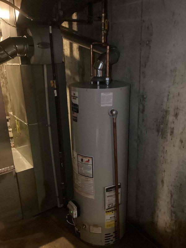 Successfully installed a 40-gallon tanked water heater in basement utility area. Completed all copper piping connections with proper elbow joints and fittings to integrate with existing plumbing system. Installed unit against concrete wall adjacent to HVAC system with appropriate clearances maintained. All connections pressure tested and verified for proper operation. Mechanical permit obtained prior to installation, with electrical reconnection completed as specified.