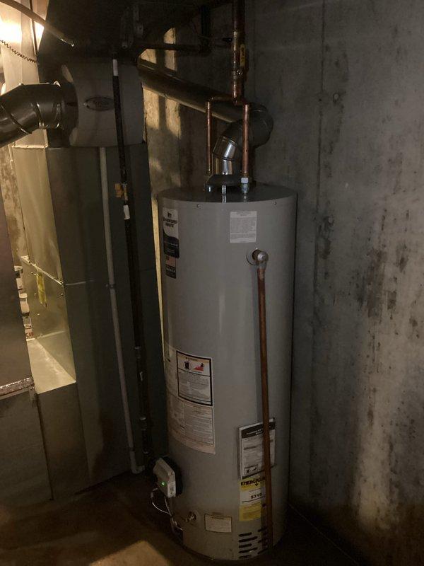 Successfully installed a 40-gallon tanked water heater in basement utility area. Completed all copper piping connections with proper elbow joints and fittings to integrate with existing plumbing system. Installed unit against concrete wall adjacent to HVAC system with appropriate clearances maintained. All connections pressure tested and verified for proper operation. Mechanical permit obtained prior to installation, with electrical reconnection completed as specified.