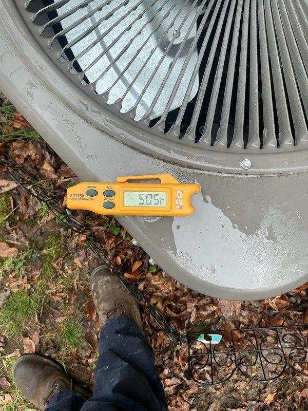 Completed annual cooling maintenance on residential outdoor condenser unit. Performed comprehensive inspection of unit exterior, verified fan grille condition, and measured discharge air temperature at 50.5°F. Cleared accumulated leaves and debris from around unit base and perimeter to ensure proper airflow and system efficiency.