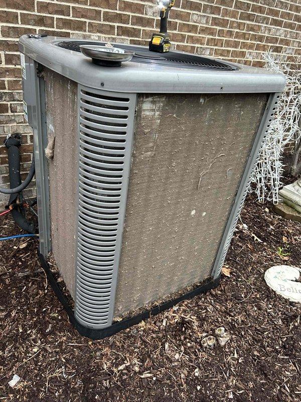 Performed annual cooling maintenance on outdoor condenser unit. Inspected unit exterior condition, noting weathering and debris accumulation on coil surfaces. Documented equipment status with photographs for service records.