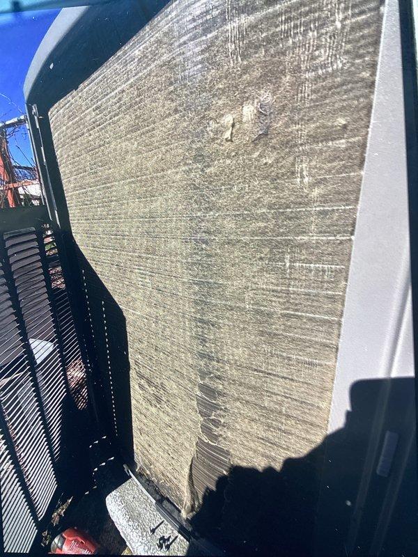 Performed scheduled ACM maintenance on rooftop HVAC unit. Inspected cylindrical condenser coil assembly and documented significant accumulation of dust, dirt, and debris on aluminum fin surfaces causing airflow restriction. Noted visible streaking, staining patterns, and mineral deposits across metallic fins indicating weathering and outdoor exposure requiring cleaning to restore optimal system performance.