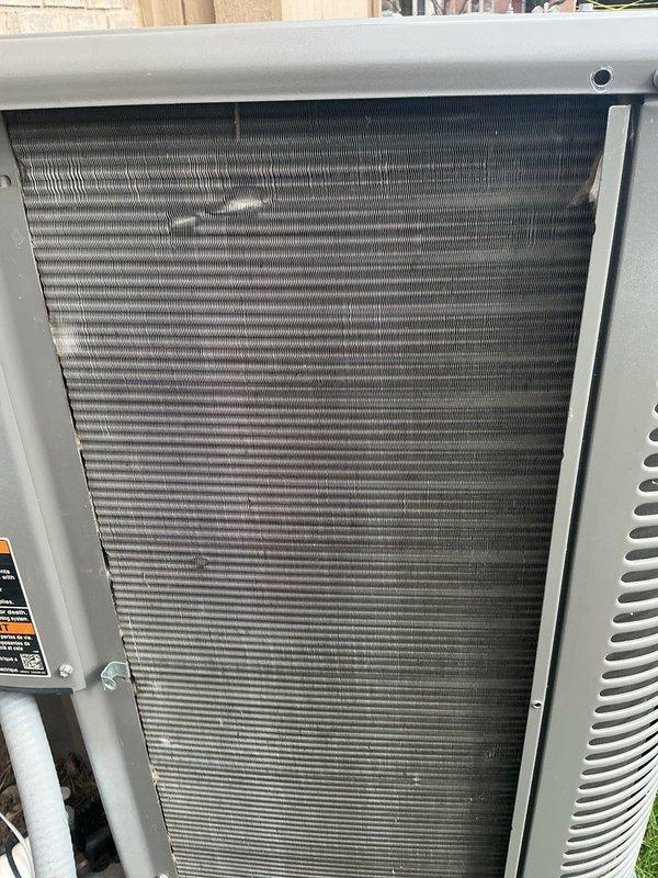 Completed scheduled air conditioning maintenance on outdoor condensing unit. Removed access panels to inspect condenser coil, which showed significant accumulation of dirt, dust, and organic debris throughout the fin surfaces. Cleaned condenser coil thoroughly to restore proper airflow and heat transfer efficiency. Replaced air filter and evaporator pad as part of routine maintenance protocol. Unit returned to normal operation with improved cooling performance.