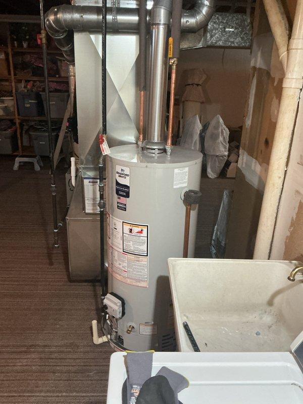 Successfully installed a 40-gallon residential tanked water heater in basement utility area. Connected copper supply lines, installed proper venting with galvanized ductwork including elbow joints and secure clamp bands, and completed all reconnections to existing plumbing system. All mechanical connections tested and verified operational with no leaks detected.
