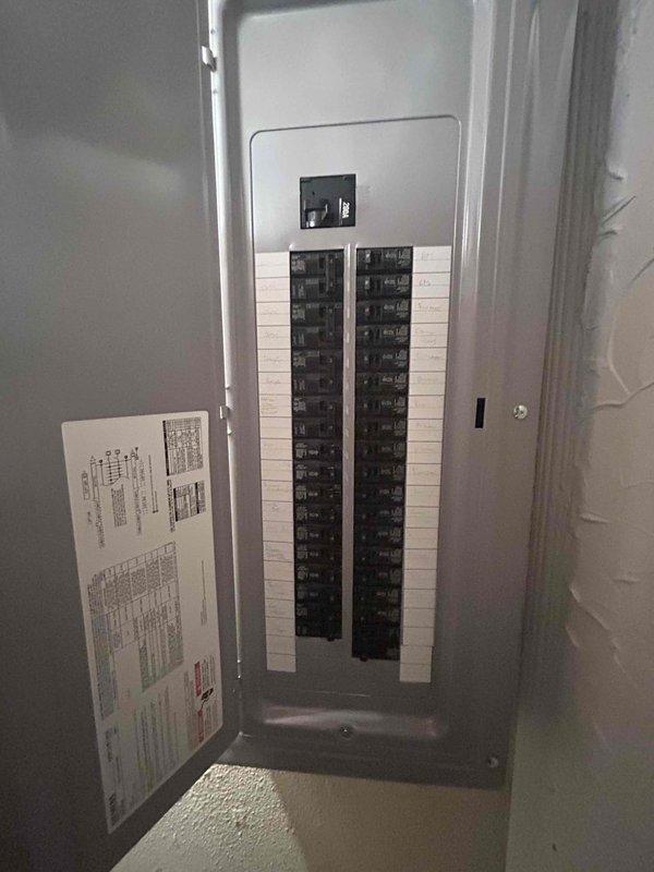 Conducted on-site assessment for heat pump replacement in basement mechanical room. Evaluated existing HVAC equipment, electrical service panel capacity with available breaker positions, and utility room layout including clearances around water heater and furnace. Documented current system configuration, electrical infrastructure, and installation requirements. Photographed mechanical equipment locations, PVC condensate routing, and electrical panel to determine compatibility and sizing specifications for new heat pump system installation.