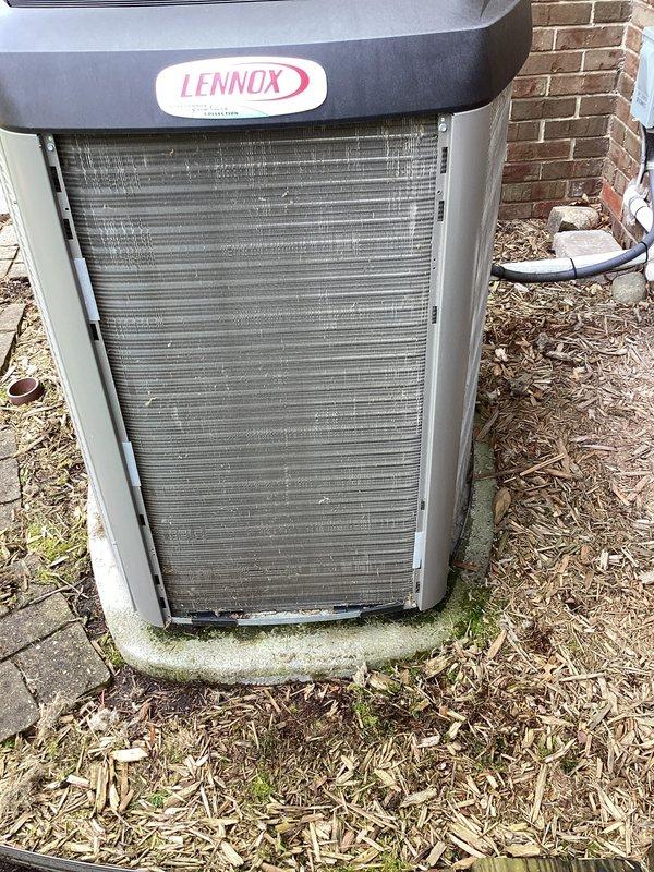 Completed annual cooling maintenance on residential Lennox air conditioning system. Performed comprehensive inspection of outdoor condenser unit, noting dirt and debris accumulation on horizontal condenser coil fins that required cleaning to restore proper airflow efficiency. Documented equipment condition with photos showing typical outdoor weathering and algae growth on concrete pad, with unit maintaining structural integrity throughout service period.