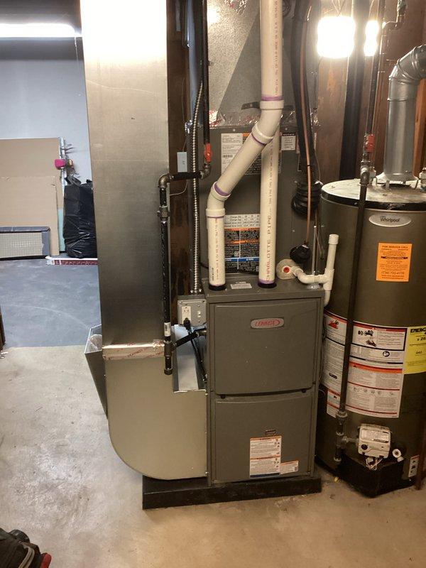 Completed full HVAC system installation including a Lennox 70,000 BTU furnace with PVC venting and a 2.5 ton air conditioning condenser unit with rear discharge configuration. Installed furnace in basement utility area with proper ductwork connections, applied liner, and completed all refrigerant line connections to outdoor condenser unit positioned on concrete pad. Obtained mechanical and refrigeration permits, reconnected all utilities, and finalized all required paperwork for system operation.