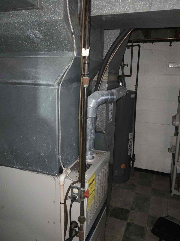 Provided estimate for complete furnace and air conditioning system replacement in basement location. Current air conditioning unit is non-operational while existing furnace remains functional. Assessed existing HVAC installation including ductwork configuration, electrical service requirements at exterior meter location, and refrigerant line routing. Documented basement equipment layout with overhead ductwork and concrete block construction for proper sizing and installation planning of replacement system.