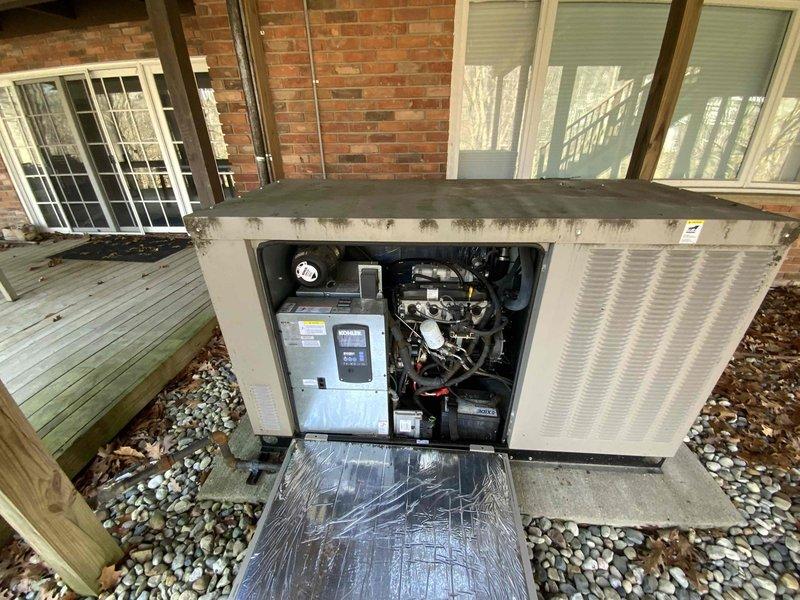 Conducted site visit to outdoor HVAC packaged unit located beneath residential deck structure. Accessed internal compartment, photographed electrical control box, motor assembly, wiring connections, and mechanical components for documentation and assessment purposes. Unit positioned on concrete pad with proper drainage and weather protection from overhead deck covering.