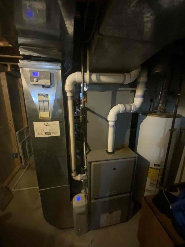 Completed on-site assessment for air conditioner replacement estimate. Existing 15-year-old AC system evaluated for replacement due to age and operational concerns. Documented current mechanical room configuration including existing furnace, air handler, water heater, and associated ductwork and plumbing connections to determine optimal placement and specifications for new air conditioning equipment installation.