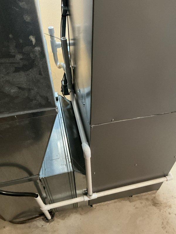 Completed full installation of 3-ton air conditioning system with evaporator coil in basement mechanical room. Unit positioned on left side with proper electrical reconnection and mechanical hookup to existing Lennox furnace system. All required mechanical, electrical, and air conditioning permits secured prior to installation. System includes proper condensate drainage with PVC piping, white intake/exhaust venting through ceiling, and integrated ductwork connections to air handler. Installation verified operational with all safety labels and manufacturer specifications properly displayed on equipment.