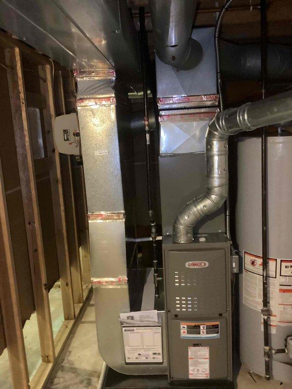 Successfully completed installation of a 2-ton air conditioning system with matching evaporator coil at rear of residence. Installed new Coleman outdoor condensing unit on grade-level pad adjacent to building exterior, connected refrigerant lines to indoor coil mounted above existing Lennox furnace in basement mechanical room. Completed all electrical connections including disconnect box and reconnection to existing power supply. All mechanical, electrical, and air conditioning permits obtained and work performed to code specifications.