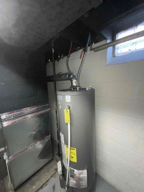 Conducted on-site assessment for air conditioning system replacement in basement location. Evaluated existing HVAC air handler unit and associated ductwork configuration, including metallic flex duct connections and current equipment installation parameters. Documented equipment positioning against concrete block foundation walls and photographed water heater proximity for clearance considerations in replacement planning. Assessed accessibility constraints within confined mechanical space and evaluated existing duct connections for compatibility with proposed replacement equipment. Prepared comprehensive estimate for complete A/C system replacement based on current non-operational status and equipment configuration requirements.