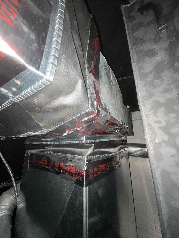 Conducted on-site assessment for air conditioning system replacement in basement location. Evaluated existing HVAC air handler unit and associated ductwork configuration, including metallic flex duct connections and current equipment installation parameters. Documented equipment positioning against concrete block foundation walls and photographed water heater proximity for clearance considerations in replacement planning. Assessed accessibility constraints within confined mechanical space and evaluated existing duct connections for compatibility with proposed replacement equipment. Prepared comprehensive estimate for complete A/C system replacement based on current non-operational status and equipment configuration requirements.