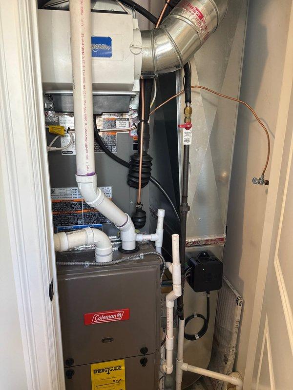 Completed full installation of 2.5-ton air conditioning system with matching evaporator coil in residential utility closet. System integrated with existing Coleman furnace, including refrigerant line set with insulation, condensate drainage connections to existing pump assembly, electrical reconnection, and ductwork modifications with metal transition elbows. All mechanical, electrical, and AC permits obtained prior to installation, with left-side condenser placement and complete system startup performed.