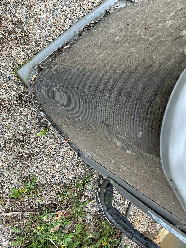 Completed Air Care Cooling maintenance on two outdoor HVAC units. Both condensers exhibited heavy accumulation of dirt, dust, and debris on heat exchanger fins, significantly reducing airflow efficiency. Cleaned and cleared organic debris including leaves and twigs from unit perimeters and coil surfaces. Inspected electrical conduit and refrigerant lines for proper condition. Units restored to optimal operating condition for continued seasonal performance.