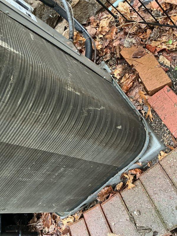 Completed Air Care Cooling maintenance on two outdoor HVAC units. Both condensers exhibited heavy accumulation of dirt, dust, and debris on heat exchanger fins, significantly reducing airflow efficiency. Cleaned and cleared organic debris including leaves and twigs from unit perimeters and coil surfaces. Inspected electrical conduit and refrigerant lines for proper condition. Units restored to optimal operating condition for continued seasonal performance.