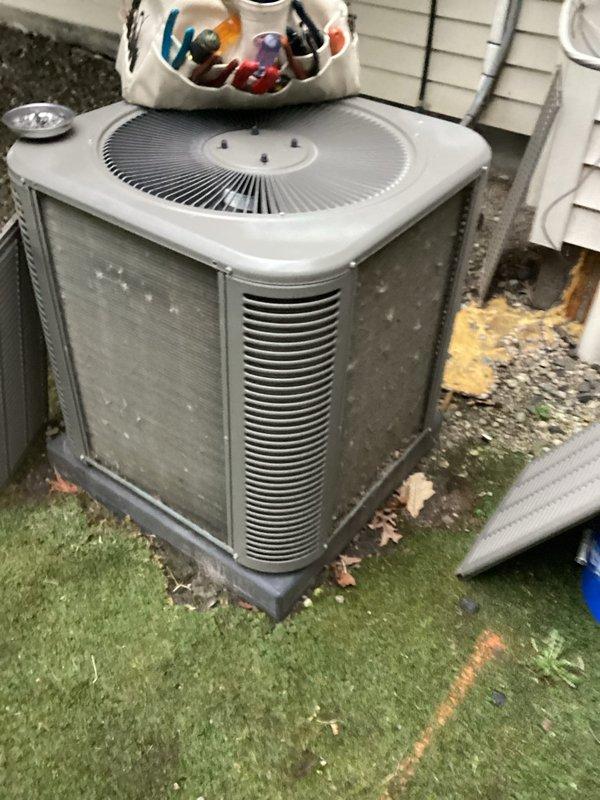 Completed comprehensive HVAC maintenance on a 5-year-old forced air heating system and air conditioning unit, both operating within normal parameters. Performed standard tune-up procedures including inspection of indoor furnace components, heat exchanger, and safety controls, as well as outdoor condenser unit evaluation with focus on fan operation, refrigerant levels, and airflow through louvered panels. Documentation captured via photos showing interior furnace cabinet with sensor mechanisms and exterior condenser unit positioned on turf with proper clearances maintained.