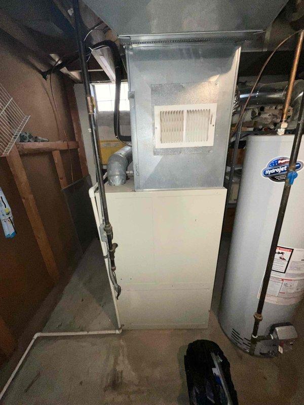 Conducted on-site evaluation of existing HVAC system in residential basement for equipment replacement estimate. Assessed 30-year-old air conditioning unit and furnace, both at end of serviceable life expectancy. Documented current equipment configuration including vertical air handler, ductwork connections, and overall system layout through photographic documentation. Provided replacement recommendations for aging equipment prior to peak cooling season.