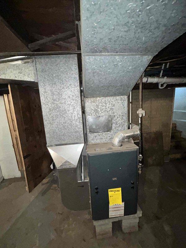 Conducted on-site evaluation for new air conditioning system installation at residential property with no existing AC unit. Assessed basement mechanical room containing existing furnace and ductwork infrastructure to determine optimal placement and integration requirements for new cooling system. Documented existing HVAC setup, ductwork configuration, and available space for equipment installation through photographic records to support equipment sizing and installation planning.