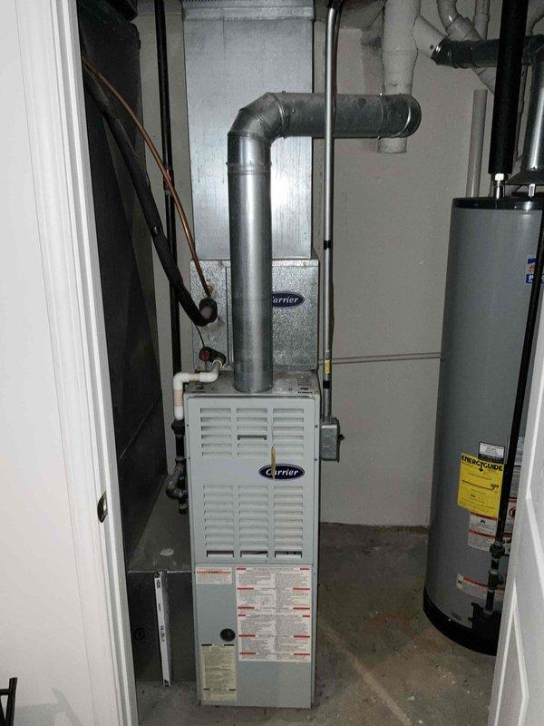 Provided comprehensive replacement estimate for 30-year-old residential HVAC system consisting of Carrier furnace and air conditioning unit located in basement with outdoor condenser. Both units remain operational but have reached end of expected service life, showing significant wear, weathering, and debris accumulation. Assessed existing installation configuration including ductwork connections, electrical disconnect, concrete pad condition, and venting system to determine optimal replacement specifications and equipment sizing requirements.