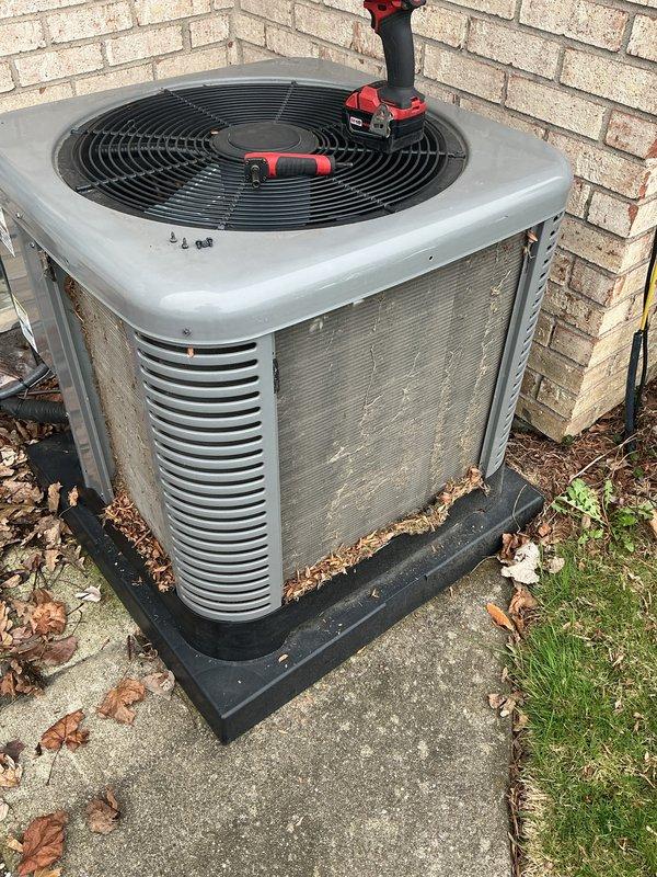 Completed annual cooling maintenance on residential outdoor condensing unit. Performed comprehensive system inspection, cleaned condenser coils, removed accumulated leaves and debris from base and mounting pad, verified refrigerant temperatures reading 76.6°F at unit surface, and confirmed proper operation of all components including fan motor and electrical connections.