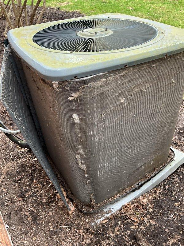 Performed annual preventive maintenance on residential split system air conditioning unit. Inspected outdoor condenser unit, noting significant deterioration of protective mesh screening with multiple tears and holes requiring future replacement. Verified electrical operation with multimeter readings showing 432 volts. Documented equipment condition with photos showing weathered exterior components, discolored top panel with debris accumulation, and compromised protective covering that may allow debris intrusion affecting unit efficiency and longevity.