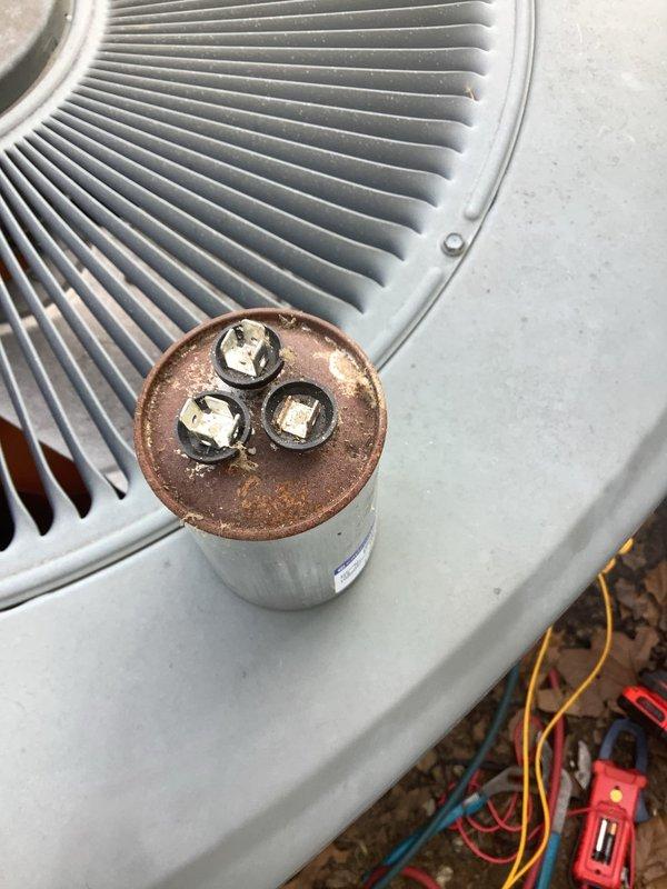 Responded to no-cooling call on 2006 outdoor condensing unit. Upon inspection, found failed dual-run capacitor with visible corrosion on electrical disconnect terminal. Performed electrical diagnostics confirming capacitor failure preventing compressor and condenser fan operation. Replaced defective capacitor, cleaned corroded electrical connections at disconnect, and verified proper voltage and amperage readings. System tested and operating within manufacturer specifications upon departure.