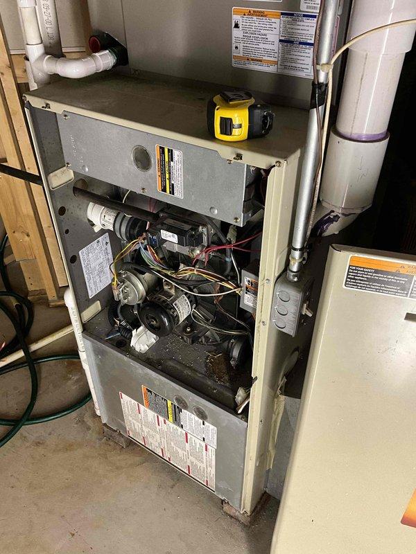Provided comprehensive estimate for furnace and air conditioning system replacement in basement installation. Current furnace is non-operational while existing air conditioning unit remains functional. Assessed aging HVAC equipment including beige furnace cabinet with exposed internal components, blower motor assembly, and associated ductwork and refrigerant lines. Documented existing system configuration including PVC venting, copper refrigerant tubing, electrical connections, and plenum arrangement. Recommended replacement of both heating and cooling units to ensure brand compatibility and system efficiency. Photographed current equipment conditions showing internal furnace components, air handler assembly, ductwork connections, and mechanical room layout to support estimate preparation.