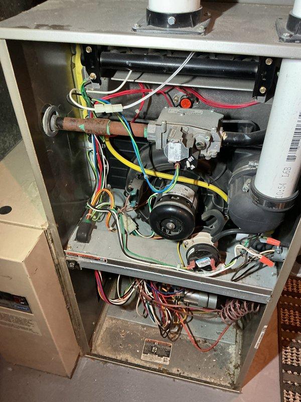 Completed routine HVAC maintenance on gas furnace unit as part of recurring Air Care Heating service agreement. Performed comprehensive inspection of all internal components including gas valve assembly, inducer motor, heat exchanger tubes, blower motors, electrical connections, and venting system. Documented existing condition of unit with interior access panel removed, verifying proper wire routing and connections throughout all colored wiring harnesses. All mechanical and electrical components found operational at time of inspection.