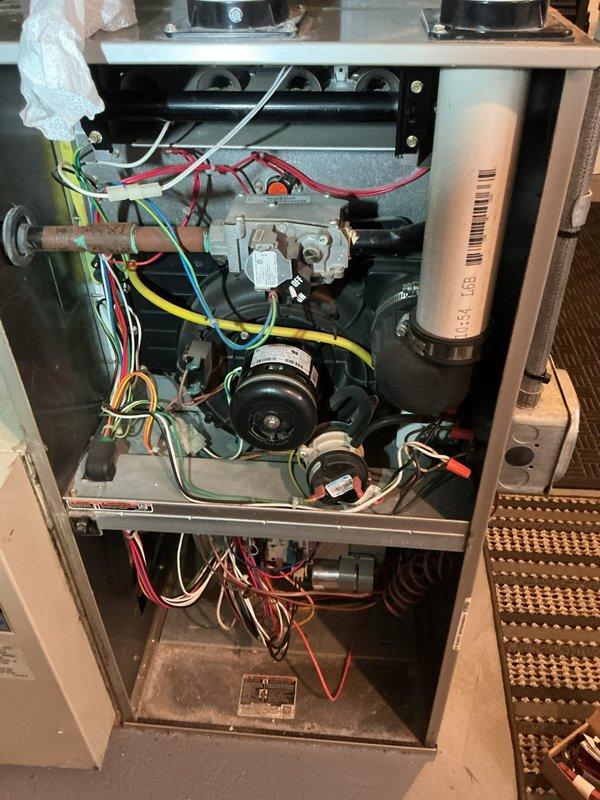 Completed routine HVAC maintenance on gas furnace unit as part of recurring Air Care Heating service agreement. Performed comprehensive inspection of all internal components including gas valve assembly, inducer motor, heat exchanger tubes, blower motors, electrical connections, and venting system. Documented existing condition of unit with interior access panel removed, verifying proper wire routing and connections throughout all colored wiring harnesses. All mechanical and electrical components found operational at time of inspection.