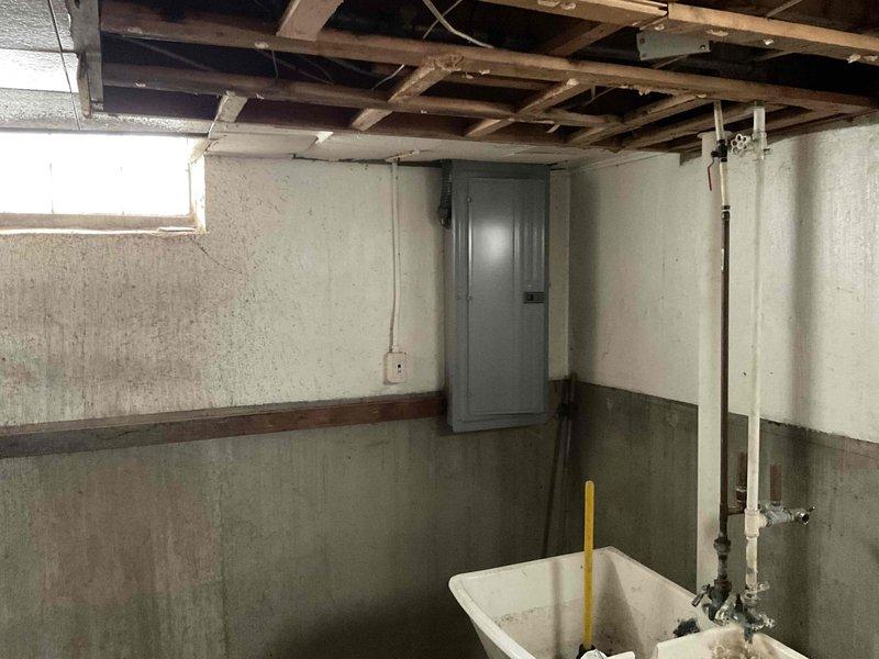 Provided estimate for air conditioning system installation at property currently without AC unit. Assessed basement location housing existing natural gas furnace and evaluated ductwork infrastructure, electrical panel access, and available space for new condensing unit and air handler integration. Documented existing HVAC configuration including sheet metal ductwork, furnace unit, and utility area conditions to determine equipment specifications and installation requirements for complete cooling system addition.